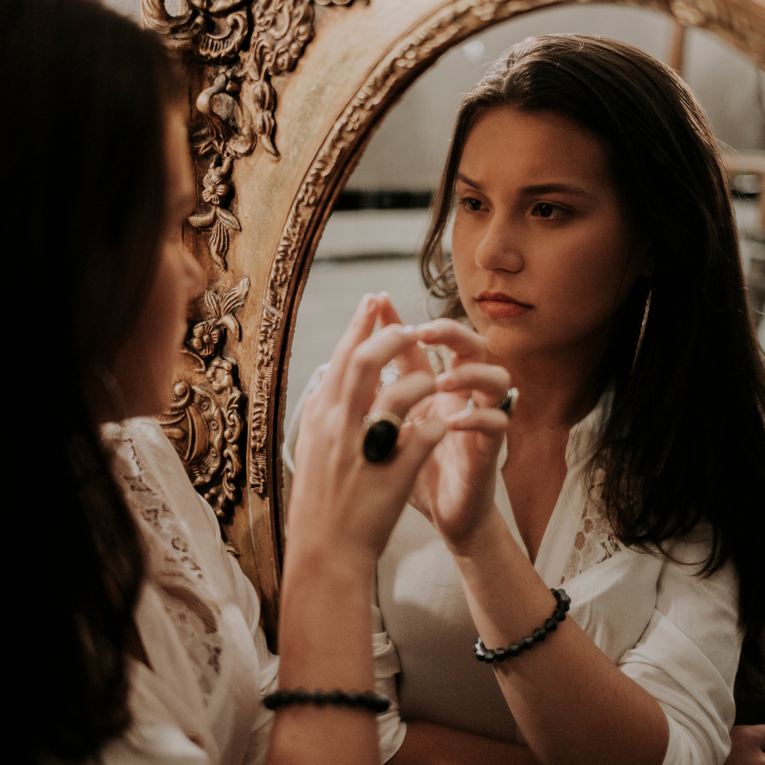 Una persona observando su reflejo en un espejo
