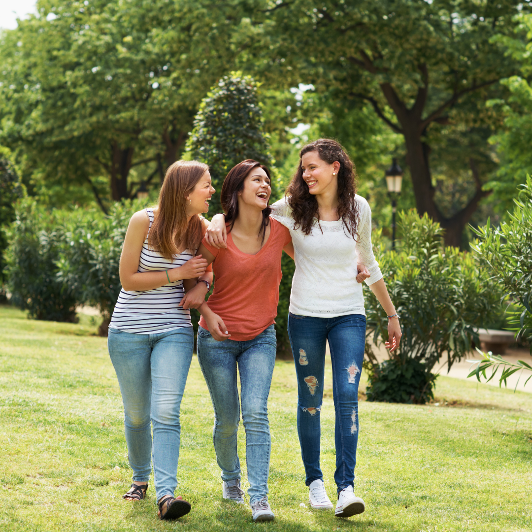 Dos mujeres caminando juntas por un parque, en una escena natural y cotidiana